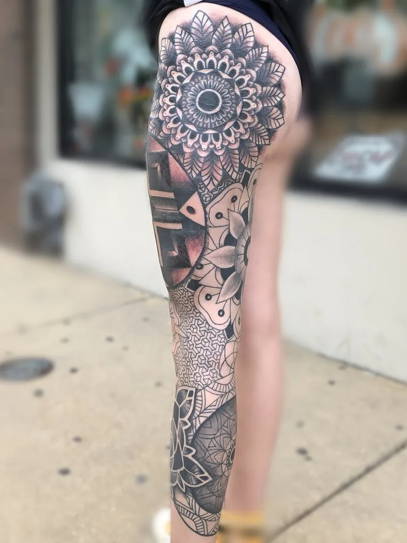 Black and grey full leg sleeve tattoo built from stacked mandalas, tessellated geometric patterns and ornamental lotuses, by Dustin Gormley at Ohana Tattoo, Waikiki, Hawaii.
